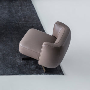 Foresta armchair by HOMAGE KOLTUK featuring a modern design with plush upholstery and wooden legs.