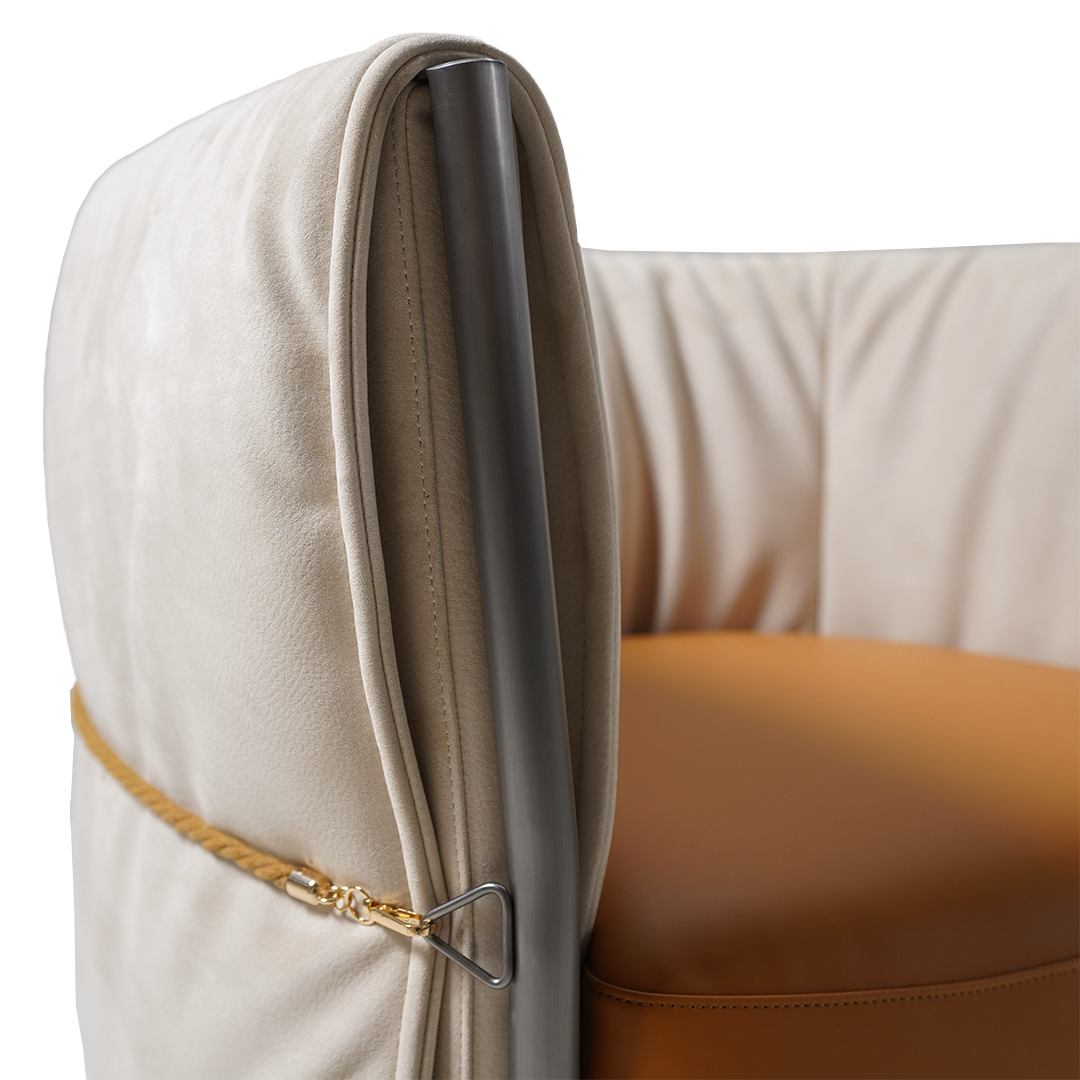 Beige Baxter armchair by BEACON with plush fabric, modern design, and cushioned seat for comfortable seating.