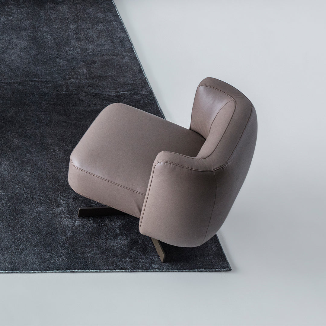Foresta armchair by HOMAGE KOLTUK featuring a modern design with plush upholstery and wooden legs.