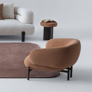 Fredа armchair by HOMAGE KOLTUK, upholstered in soft fabric with a modern design and wooden legs, perfect for living room seating.
