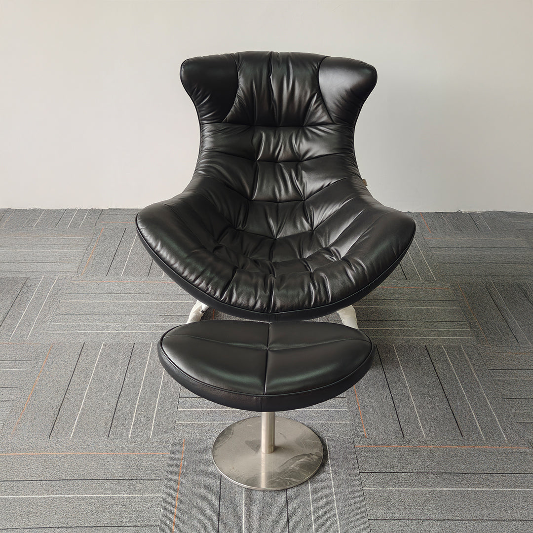 Vexel black lounge chair with matching ottoman from BEACON, modern design with smooth curves and cushioned seating.