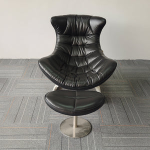 Vexel black lounge chair with matching ottoman from BEACON, modern design with smooth curves and cushioned seating.