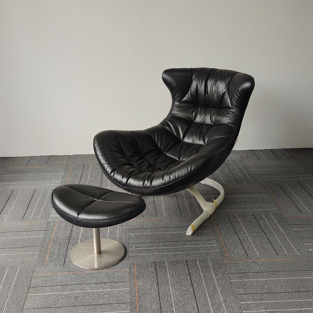 Black Vexel lounge chair with matching ottoman by BEACON, modern design, plush upholstery, and sleek legs perfect for relaxing spaces.
